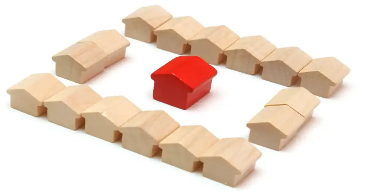 small house made wooden blocks is surrounded by row houses